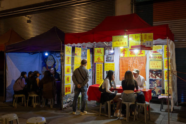 Hong Kong - December 31, 2023 : Fortune tellers are offering readings at the Temple Street Night Market in Hong Kong.